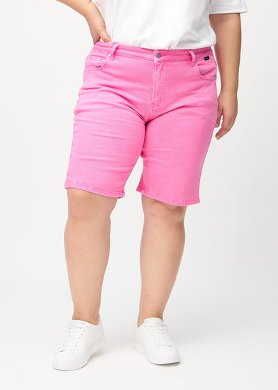 Lyserøde regular middle shorts, modelnavn Flamingos, som går lige ned langs benet og slutter lige over knæet på en plus-size model, set forfra.