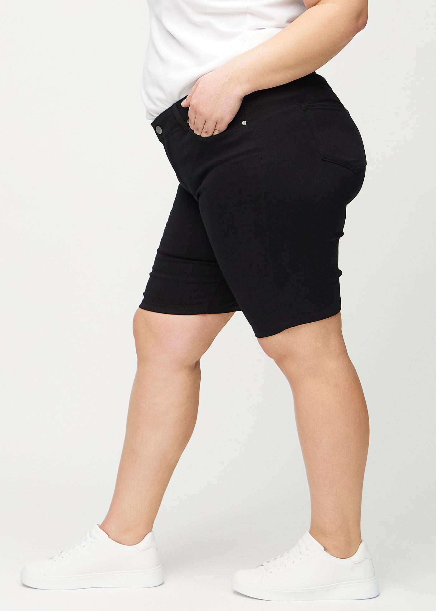 Sorte skinny middle shorts set fra siden på en plus-size model.