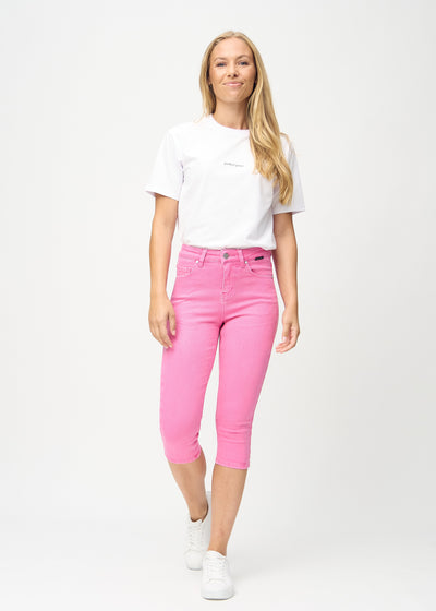 Fuldt billede af model i lyserøde skinny capris.