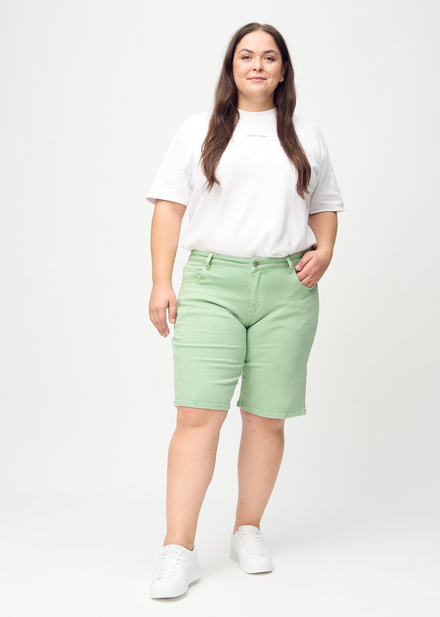 Fuldt billede af en plus-size model i lysegrønne regular middle shorts.