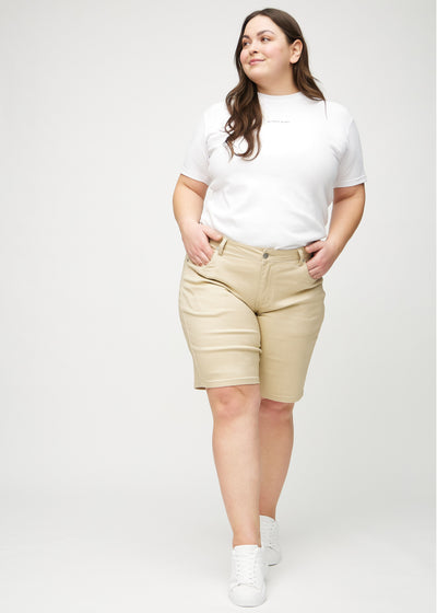 Fuldt billede af en plus-size model i beige regular middle ultra high rise shorts.