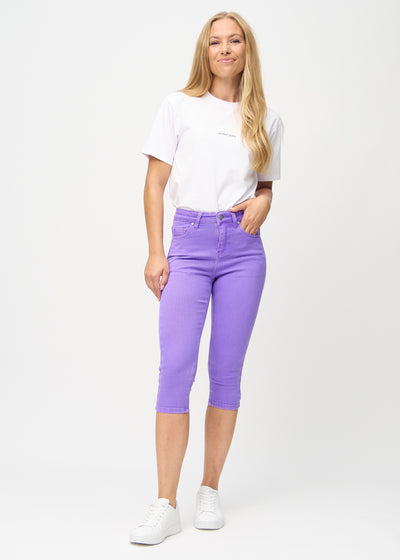 Fuldt billede af model i lilla skinny capris.