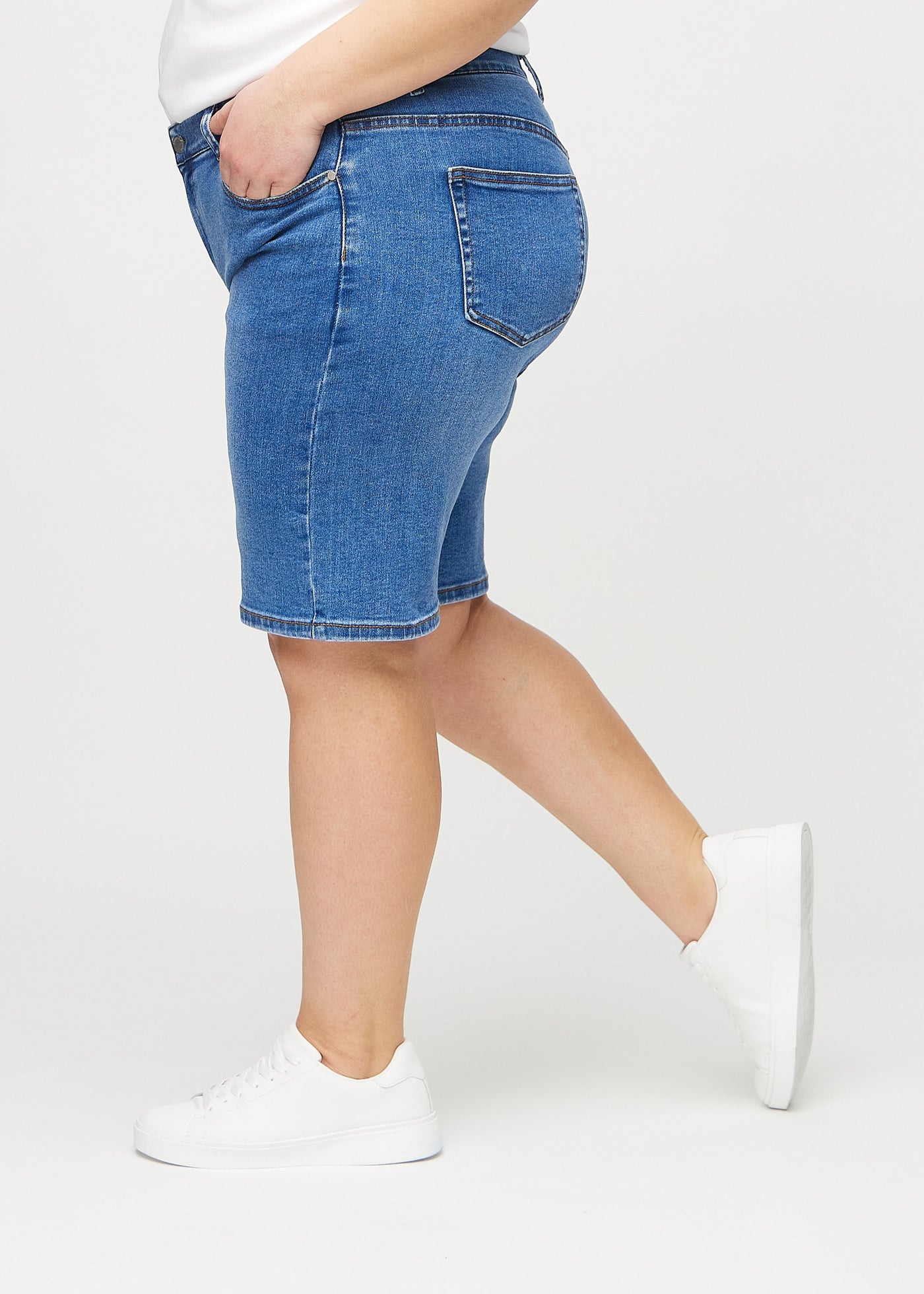 Denim regular middle shorts set fra siden på en plus-size model.