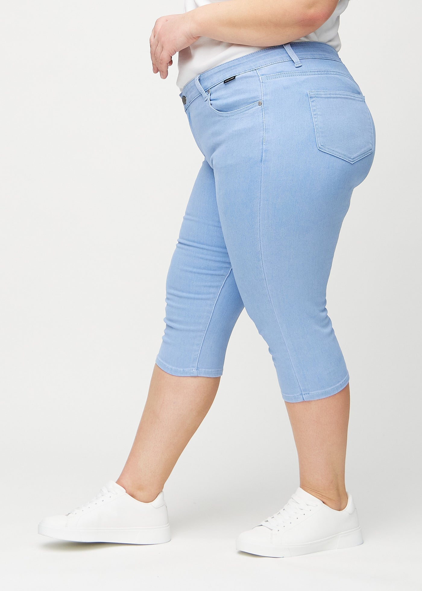 Lyseblå skinny capris set fra siden på en plus-size model.