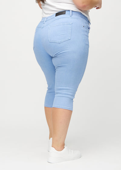 Lyseblå skinny capris set bagfra på en plus-size model, så man kan se hele produktet.