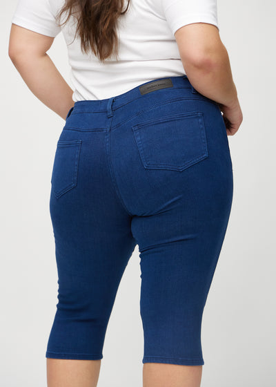 Mørkeblå skinny capris set bagfra tæt på en plus-size model for at vise detaljer.