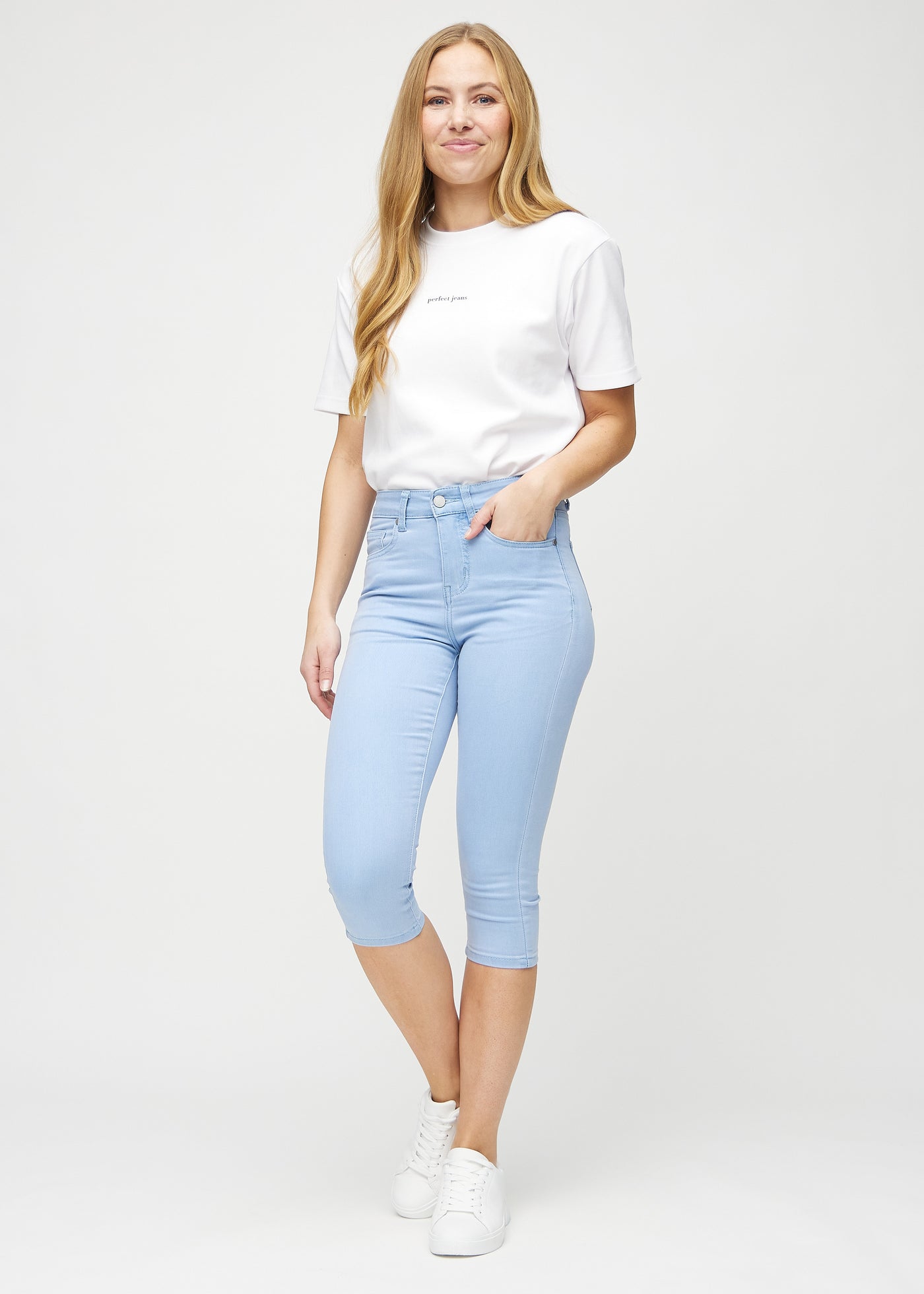 Fuldt billede af model i lyseblå skinny capris.