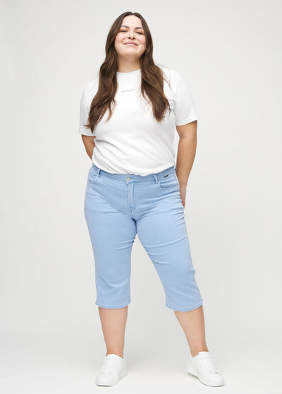 Fuldt billede af en plus-size model i lyseblå regular capris.