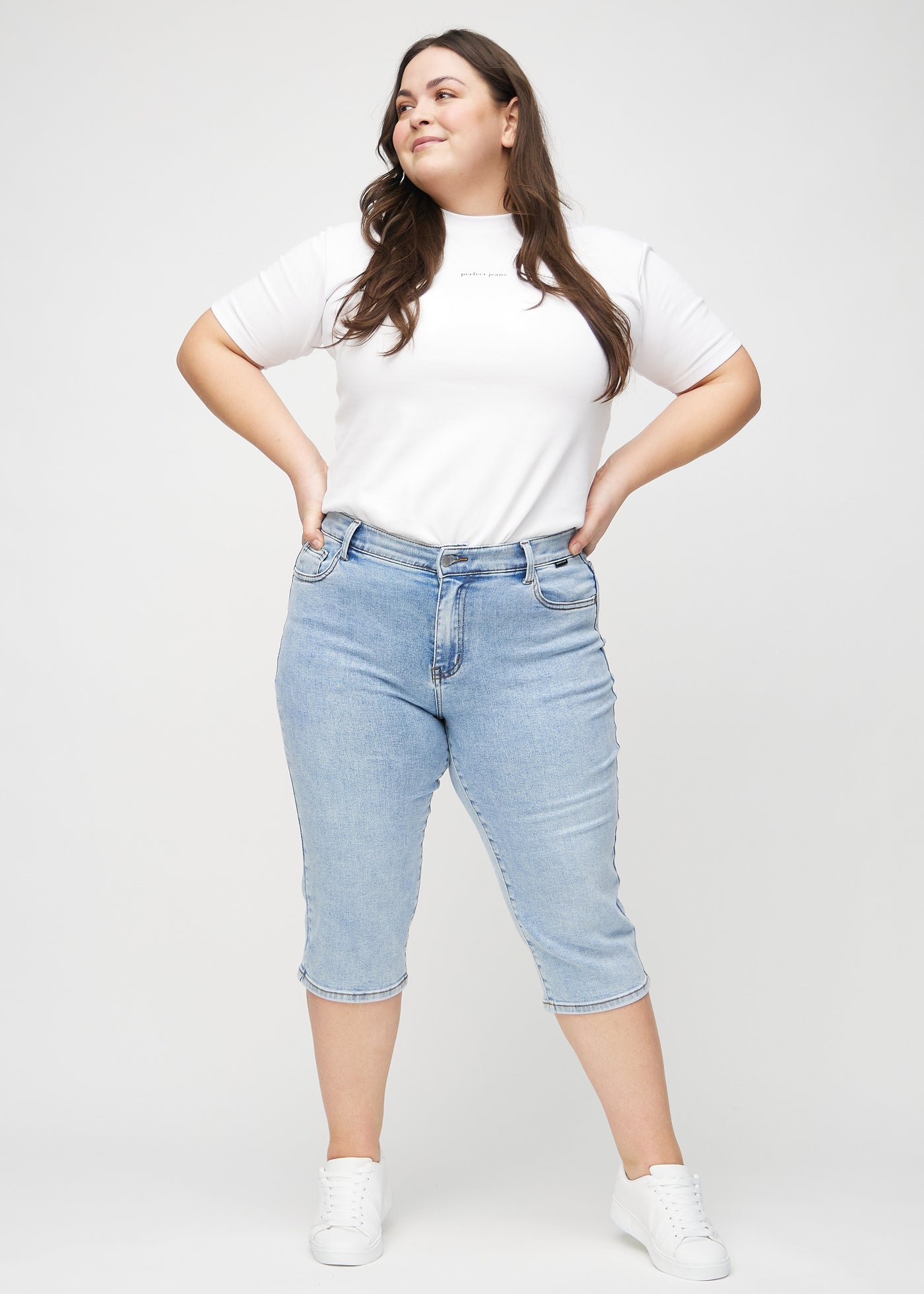 Fuldt billede af en plus-size model i lys denim regular capris.