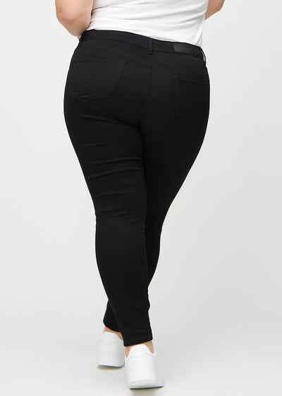 Sorte skinny jeans set bagfra på en plus-size model, så man kan se hele produktet.