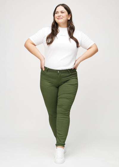 Fuldt billede af en plus-size model i mørkegrønne skinny jeans.