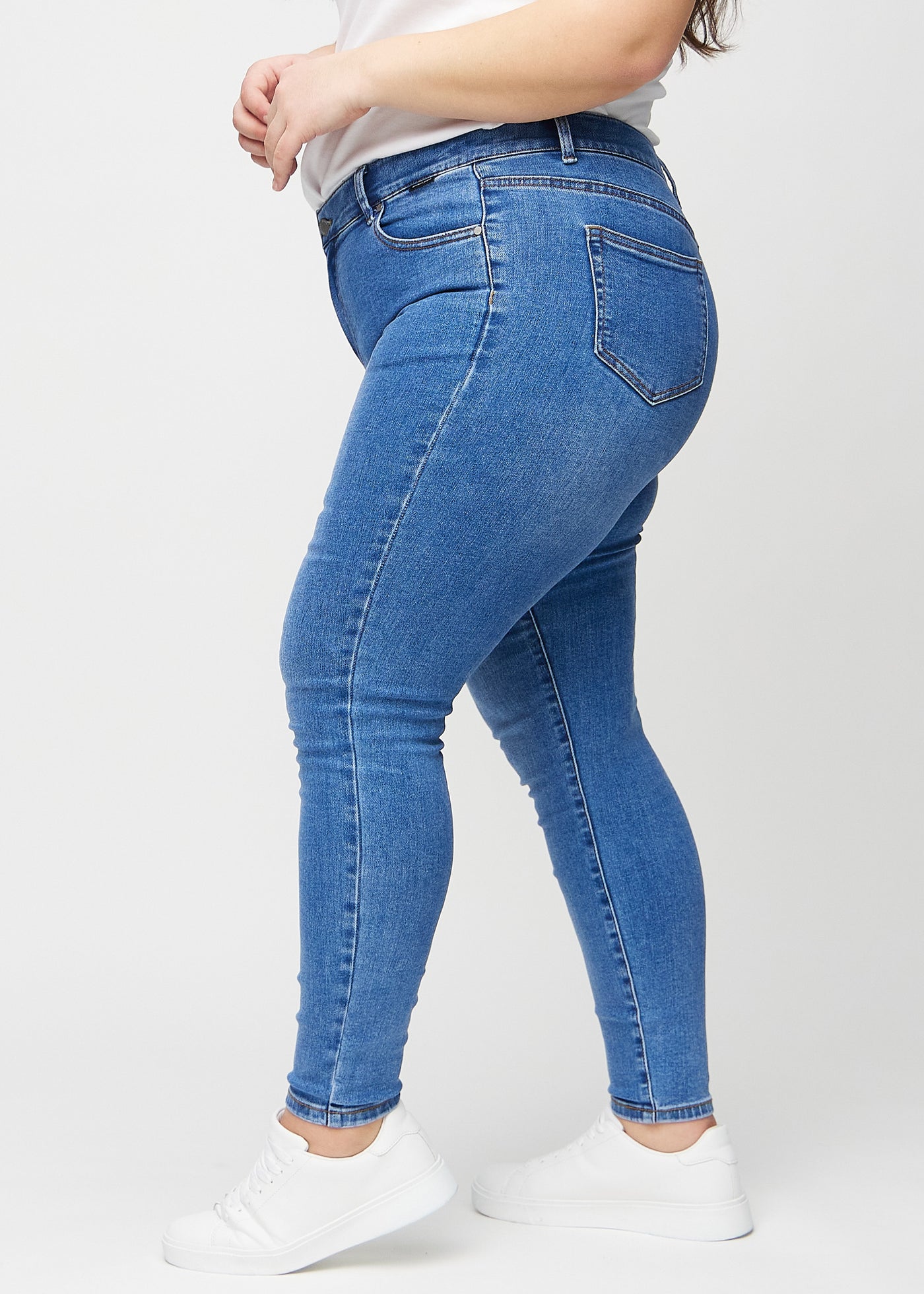 Denim skinny jeans set fra siden på en plus-size model.