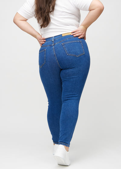 Mørk denim skinny jeans set bagfra på en plus-size model, så man kan se hele produktet.'