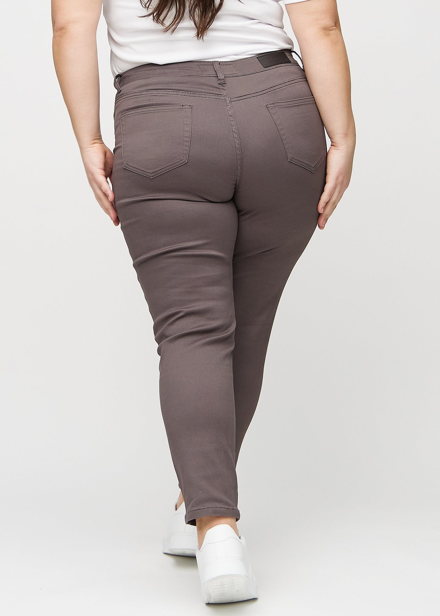 Gråbrune slim jeans set bagfra på en plus-size model, så man kan se hele produktet.