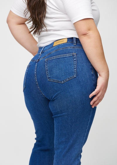 Mørk denim slim jeans set bagfra tæt på en plus-size model for at vise detaljer.