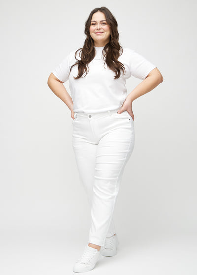 Fuldt billede af en plus-size model i hvide regular jeans.