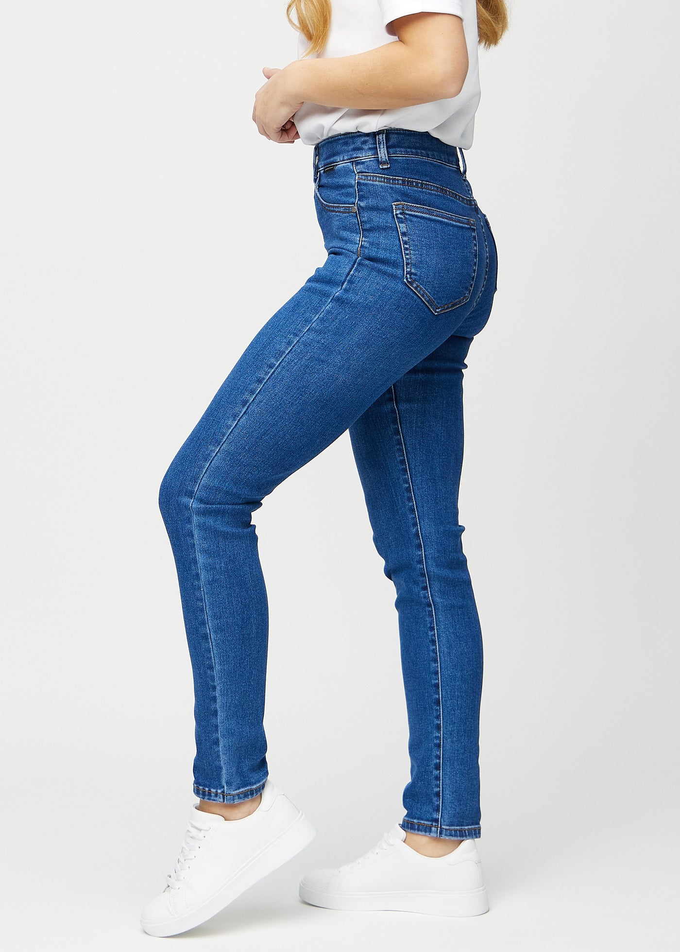 Mørk denim slim ultra high rise jeans set fra siden på model.