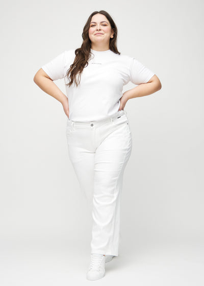 Fuldt billede af en plus-size model i hvide loose jeans.