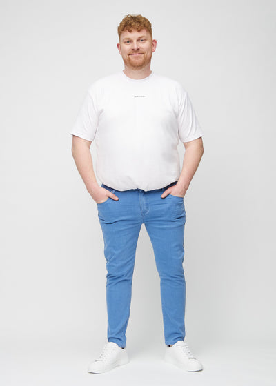 Fuldt billede af en plus-size model i blå slim jeans.