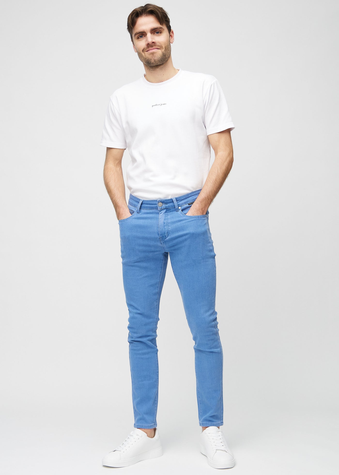 Fuldt billede af model i blå slim jeans.