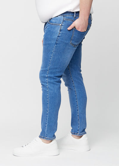 Denim slim jeans set fra siden på en plus-size model.