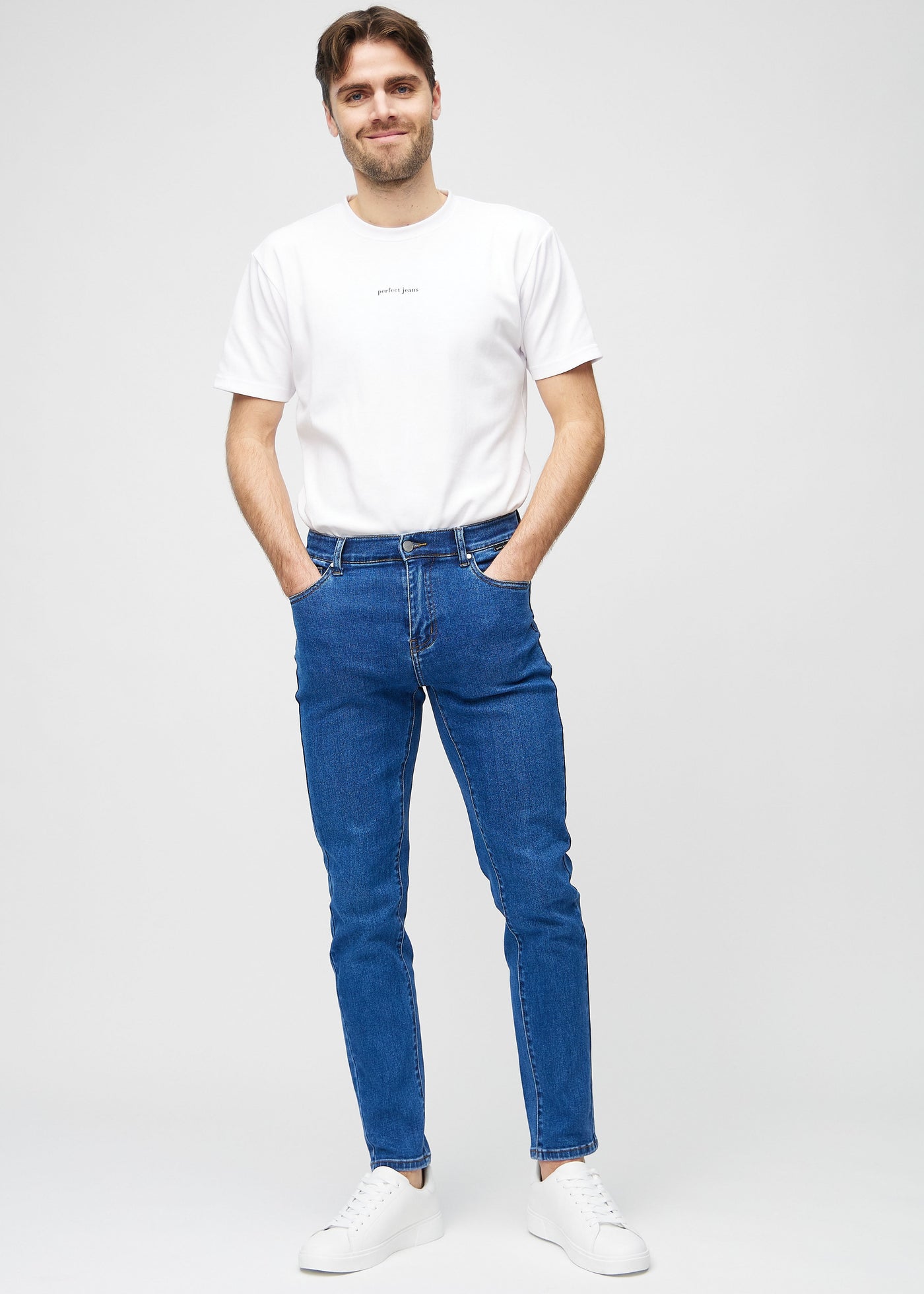 Fuldt billede af model i mørk denim slim jeans.