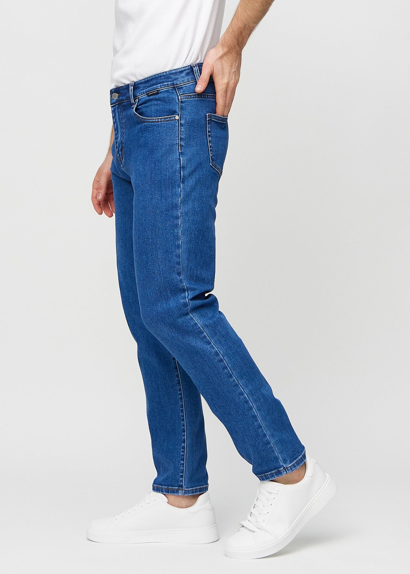 Mørk denim regular jeans set fra siden på model.