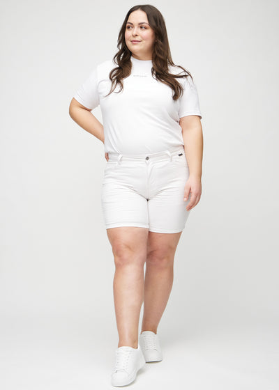 Plus-size model går ind i billedet, strækker i sine shorts, viser dem frem ved at dreje rundt, og forlader derefter billedet.