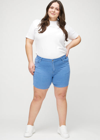 Plus-size model går ind i billedet, strækker i sine shorts, viser dem frem ved at dreje rundt, og forlader derefter billedet.